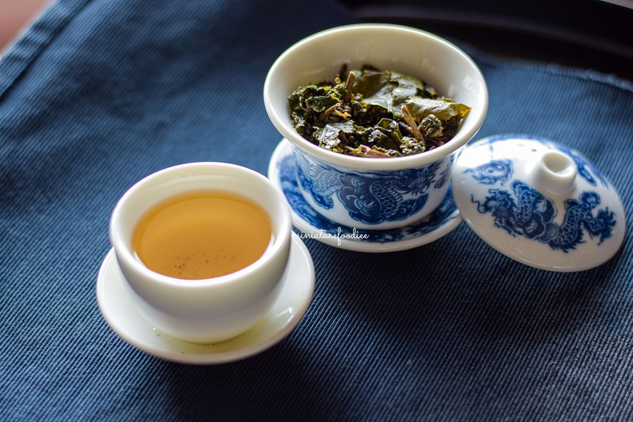 Steeped Oolong Tea in a white cermaic cup and gaiwan