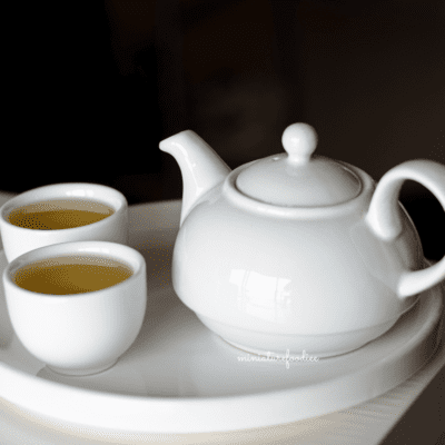 Tea in a white tea kettle and cups