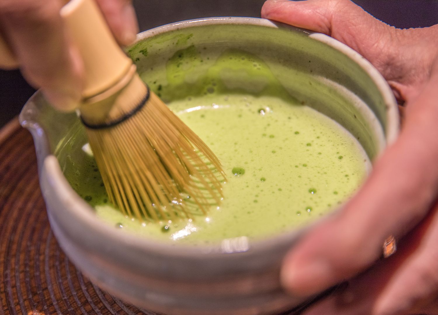 foamed matcha tea with a wooden whisk